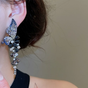 Detailed close-up of butterfly tassel earrings with blue and black zircon crystals