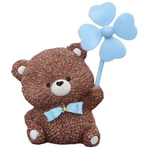 Brown resin teddy bear car ornament holding a blue windmill on a white background