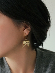 Minimalist matte gold geometric earrings with hammered texture on female model