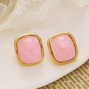 Vue macro de boucles d'oreilles carrées plaquées or avec inserts en résine marbrée rose