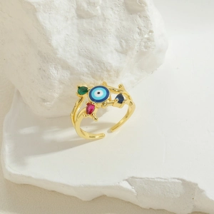 Vintage golden evil eye open ring with colorful zircon accents on a white rock