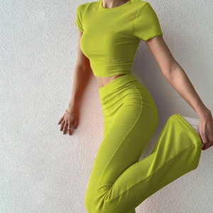 Dettaglio del tessuto a costine verde lime su un set alla moda con crop top e pantaloni ampi