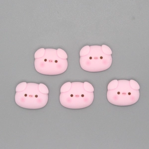 Flat lay macro of five cute pink resin pig head charms for DIY handmade jewelry crafting
