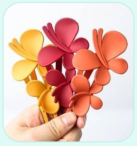 Detail showing assorted large matte butterfly hair clips in yellow, burgundy and orange