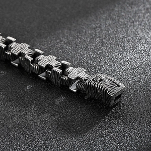 Macro close-up showing the industrial relief texture and silver steel links of the bracelet