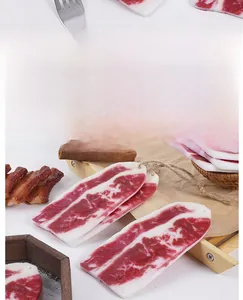 Realistic artificial bacon slices made of PVC with rustic kitchen prop background