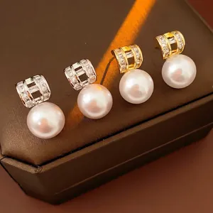 French vintage gold and silver pearl earrings with micro-set zircons on a jewelry box
