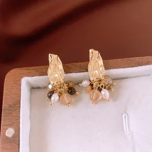 Vintage style gold earrings with pearl tassels and amber beads in a jewelry box