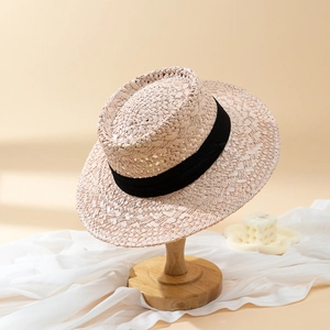 Classic straw sun hat with black ribbon decoration on a display stand for summer