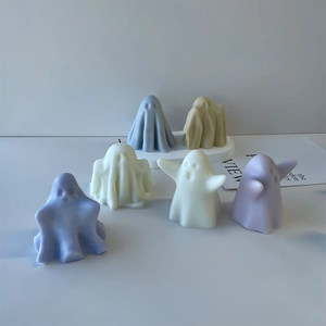 Detailed view of colorful ghost-shaped candles in light blue, beige, white, and purple