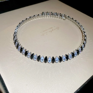 Makroaufnahme von Silberarmband mit schwarzen und klaren Edelsteinen in Geschenkbox