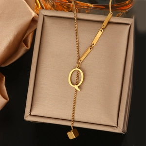 Detailweergave van de gouden titanium stalen ketting met een letter Q hanger