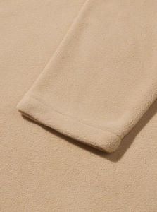 Detailed macro view of the sleeve cuff stitching on a beige fleece hoodie sweatshirt