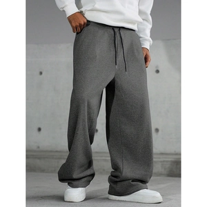 Detail of loose dark grey knit sweatpants with adjustable elastic drawstring waistband