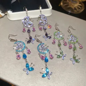 Three pairs of floral tassel earrings with moon and butterfly designs in silver setting