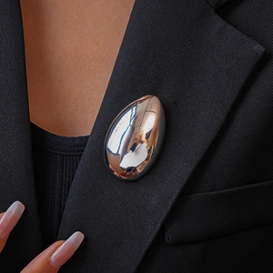 Polished silver teardrop brooch pinned on a black suit lapel for a sophisticated look