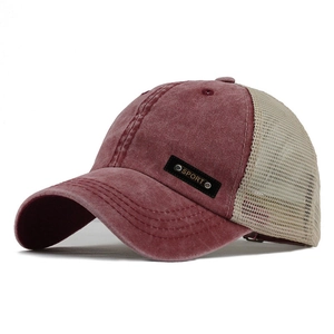 Detail of washed red cotton baseball cap with beige mesh back and black SPORT patch