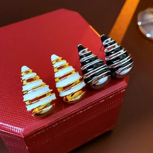 Close-up of vintage spiral enamel earrings in gold and silver on a velvet jewelry box