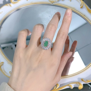 Elegant 925 silver ring with a green oval gemstone and halo of white diamonds