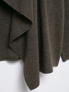 Macro shot of dark brown fine-knit fabric showing soft wool texture and smooth drape