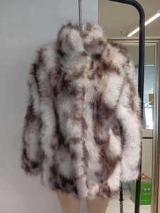 Detail of plush faux fur coat with brown leopard spots, high collar, and thick texture