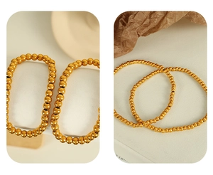 Detail view of thin and thick gold polished beaded bracelets on minimalist beige background