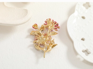 Detail view of the golden metal back and pin closure of the floral brooch