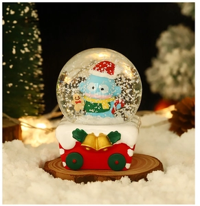 Close-up of glowing Christmas crystal ball featuring Hangyodon in red Santa hat on gift car