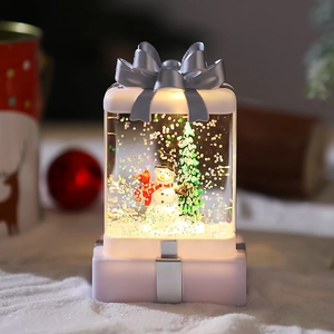 Macro view of luminous Christmas snow globe with snowman and sparkling glitter inside