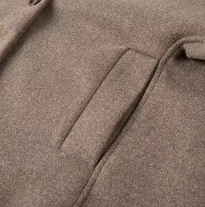 Detail shot of a brown wool coat featuring side pocket construction and fine stitching