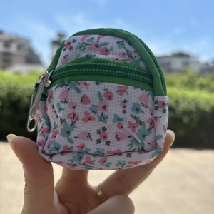 Macro detail of mini backpack coin purse with floral pattern and dark green zipper