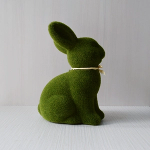 Close-up of green flocked moss bunny ornament with a yellow ribbon for Easter decor