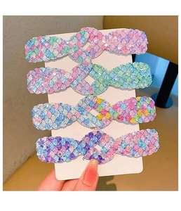 Vue détaillée de quatre barrettes en forme de queue de sirène à paillettes sur carte