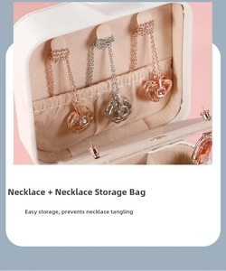 Close-up of portable jewelry box showing necklace hooks and beige suede storage pouch