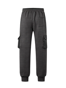 Detail of dark grey quilted cargo pants showing waffle texture and side flap pockets