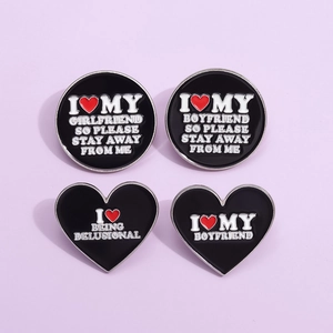 Set of 4 black enamel heart and round pins with white slogan engravings for clothing