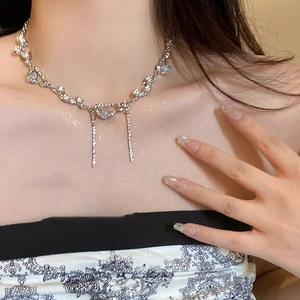 Close-up of heart crystal and pearl beaded necklace on model with silver-tone metal chains