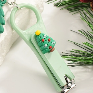 Christmas tree design nail clipper with bottle opener on white stone and pine branch