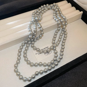 Detail view of metallic grey layered pearl necklace displayed on professional jewelry tray