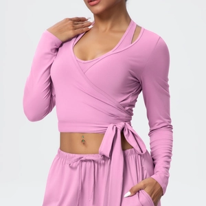 Pink cross-tie long sleeve top and matching leggings shown in a yoga workout pose