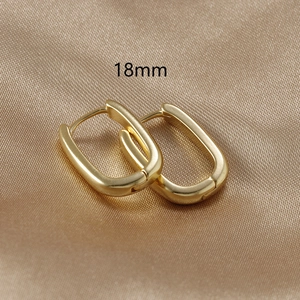 Minimalist 18k gold plated U-shaped rectangular earrings displayed on champagne silk fabric