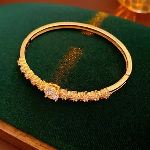Gold plated flower bangle with cubic zirconia oval stone on a green velvet box