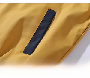 Detailed macro view of ginger yellow jacket featuring contrast navy blue waist pocket