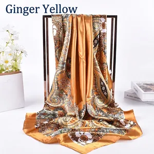 Detail of ginger yellow paisley silk scarf hanging on a metal rack for spring fashion