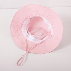 Detail view of pink sun hat with wide brim, breathable mesh lining and adjustable chin strap