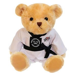 Ours en peluche portant un uniforme de taekwondo blanc avec ceinture noire