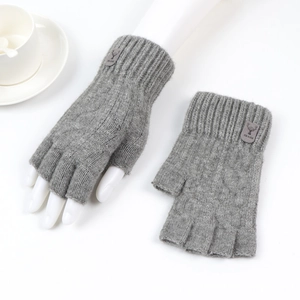 Detail of gray knitted fingerless gloves with ribbed cuffs and leather deer head patch