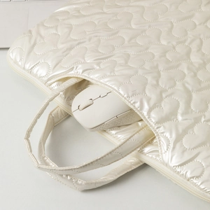 Detail view of heart-quilted laptop bag with pearl finish and convenient outer pocket