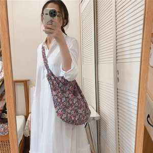 Mirror selfie showing large vintage floral canvas crossbody bag with colorful flower patterns