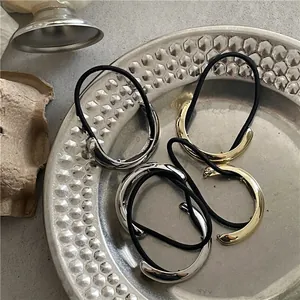 Minimalist gold and silver polished metal half-round ponytail cuffs with elastic bands